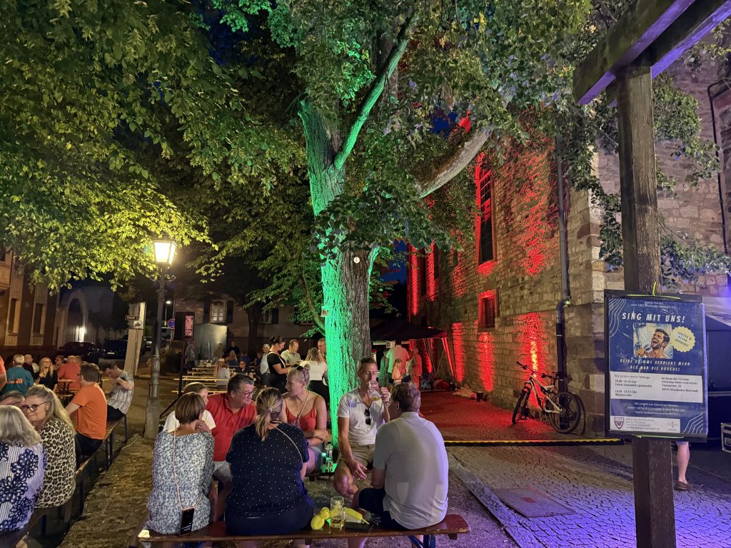Pfarrer-Ruhl-Platz mit Gästen  wunderschön angeleuchtet 